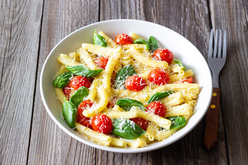 Pasta casarecce with tomatoes, basil and cheese. Italian cuisine. Vegetarian food.