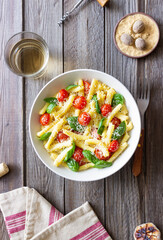 Pasta casarecce with tomatoes, basil and cheese. Italian cuisine. Vegetarian food.