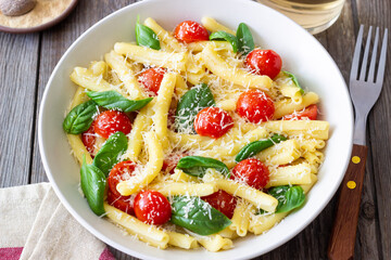 Pasta casarecce with tomatoes, basil and cheese. Italian cuisine. Vegetarian food.
