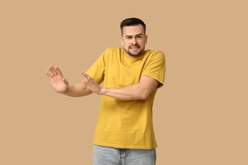 Handsome ashamed young man on brown background
