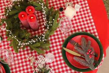 Christmas table setting with burning candles and wreath
