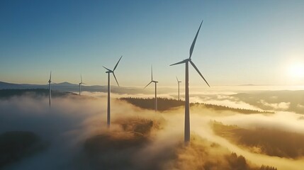 Majestic wind turbines pierce a misty sunrise landscape, showcasing clean energy amidst rolling hills