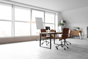 Interior of light conference hall with window, table and armchairs