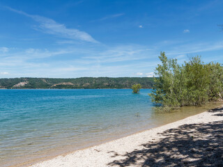  Parc Régional du Verdon. Petite plage de sable au bord du lac de Sainte-Croix entre Bauduen et Costebelle avec vue le village Sainte-Croix-du Verdon à l'horizon. 

