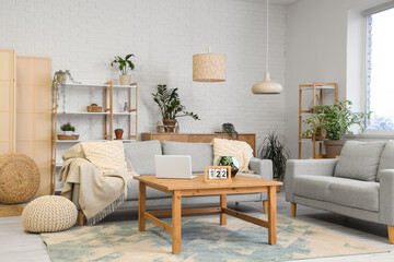 Stylish interior of beautiful living room with comfortable sofas, houseplants, shelving units and...