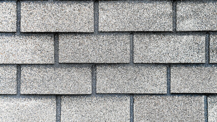 Textured gray concrete block wall with a uniform pattern, showcasing the rough surface and subtle...