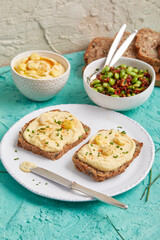 Hummus on bread slices with edamame salad in a bowl