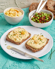 Hummus on bread slices with edamame salad in a bowl