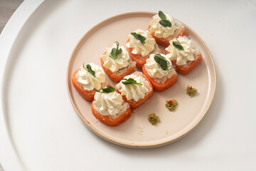 Homemade rolls with red fish and cottage cheese on a plate on a white background