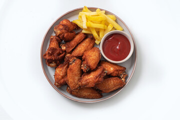 Chicken legs and wings with sauce on a plate on a white background