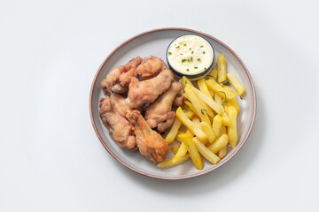 Chicken legs and wings with sauce on a plate on a white background