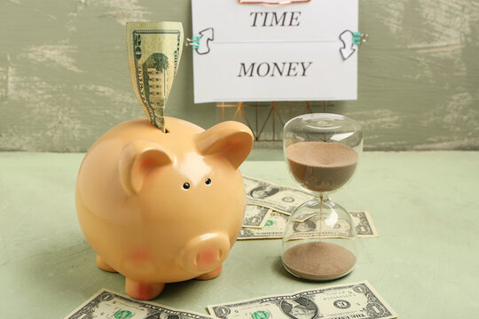 Composition with piggy bank, hourglass and dollar banknotes on table against grunge background. Time management concept - Powered by Adobe