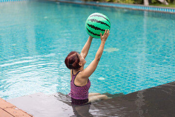Senior asian woman have relax and recreation on swimming pool.