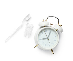 Alarm clock and toothbrush isolated on white background