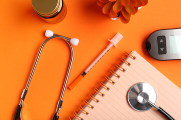Set of medical supplies and notebook on orange background, closeup