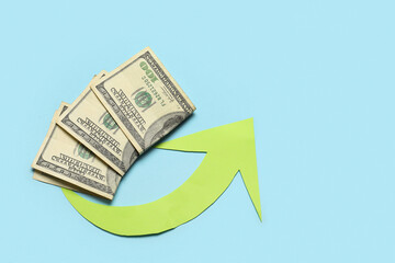 Arrow with dollar banknotes on blue background. Price rise concept