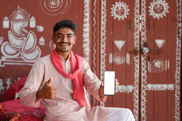 young indian farmer showing smartphone screen