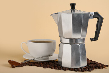 Geyser coffee maker with cup, spoon and beans on beige background