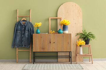 Stylish interior of modern hall with chest of drawers and ladder