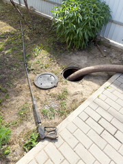 A hose is being used to clean a drain