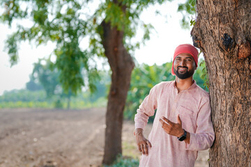 indian farmer standing at agricultural field
