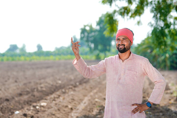 indian farmer standing at agricultural field
