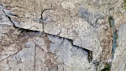 Close-up of a natural mountain rock surface featuring rough and organic textures. Ideal for use in backgrounds, design elements.