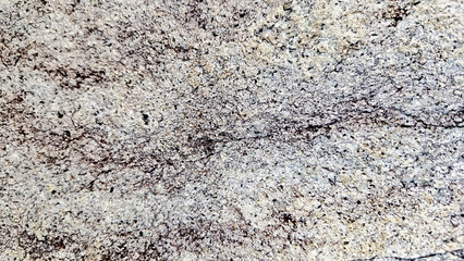 Close-up of a natural mountain rock surface featuring rough and organic textures. Ideal for use in backgrounds, design elements.