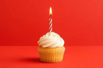 Cupcake de vainilla con crema blanca y vela encendida sobre fondo rojo, concepto de cumpleaños, celebración y dulces festivos