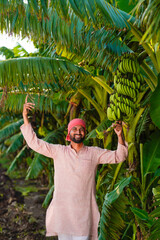 young indian farmer standing at banana field