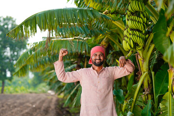 young indian farmer standing at banana field