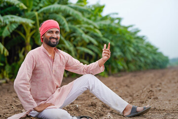 young indian farmer sitting in the field