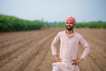 indian farmer standing at agricultural field
