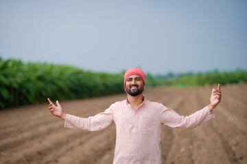 indian farmer standing at agricultural field