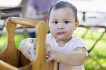Fototapeta premium Baby is enjoying leisure time outdoors with family during picnic, surrounded by people and nature, capturing concept of joyful moments and togetherness in natural setting