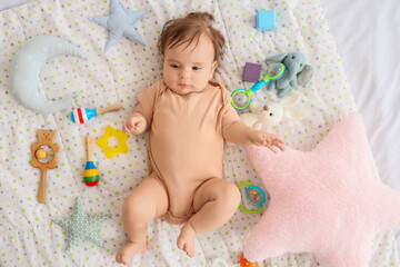 Cute little baby with toys lying on blanket, top view