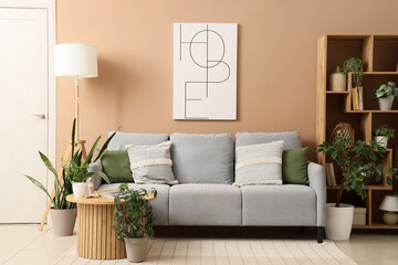 Sofa, coffee table, shelving unit and houseplants in interior of living room