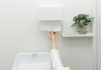 トイレでペーパータオルを使う女性の手