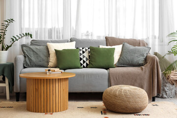 Interior of living room with grey sofa, table and plaids