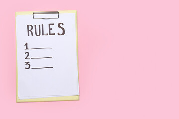 Clipboard with blank list of rules on pink background