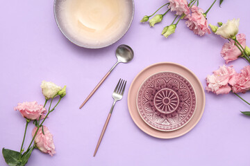 Stylish table setting with beautiful eustoma flowers on lilac background