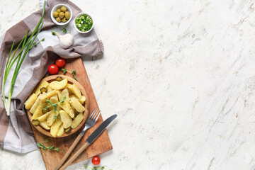 Wooden plate of tasty potato salad with pickled cucumber and tomatoes on white background