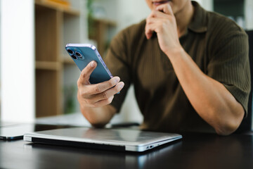 Confident businessman working on laptop, tablet and smartphone at her workplace