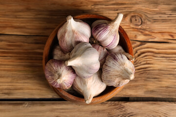 Bowl with fresh garlic on wooden background