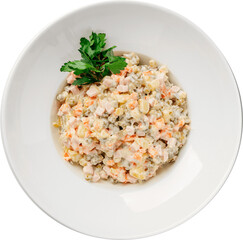 Olivier salad, a popular Russian dish, served on a white plate with fresh parsley garnish.