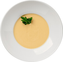 Creamy yellow soup garnished with fresh parsley, served in a white bowl.