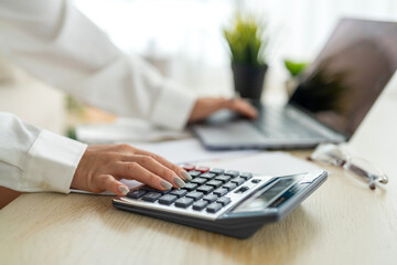 Human use calculator and calculate bills and paying bill, credit card, tax and vat, payment, concept of money management and business report with financial documents, financial accounting concept