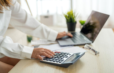 Human use calculator and calculate bills and paying bill, credit card, tax and vat, payment, concept of money management and business report with financial documents, financial accounting concept