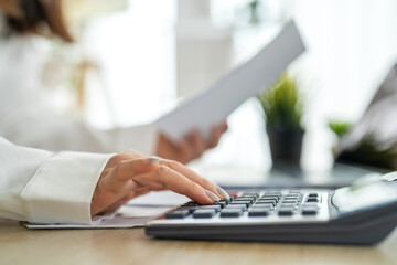 Human use calculator and calculate bills and paying bill, credit card, tax and vat, payment, concept of money management and business report with financial documents, financial accounting concept