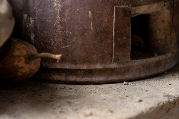 A close-up of a traditional rustic clay or charcoal stove (bep than) in a Vietnamese countryside kitchen. An atmospheric still life image representing a simple, traditional way of life and cooking.

